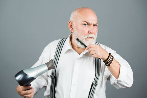 Man standing with blow dryer and comb